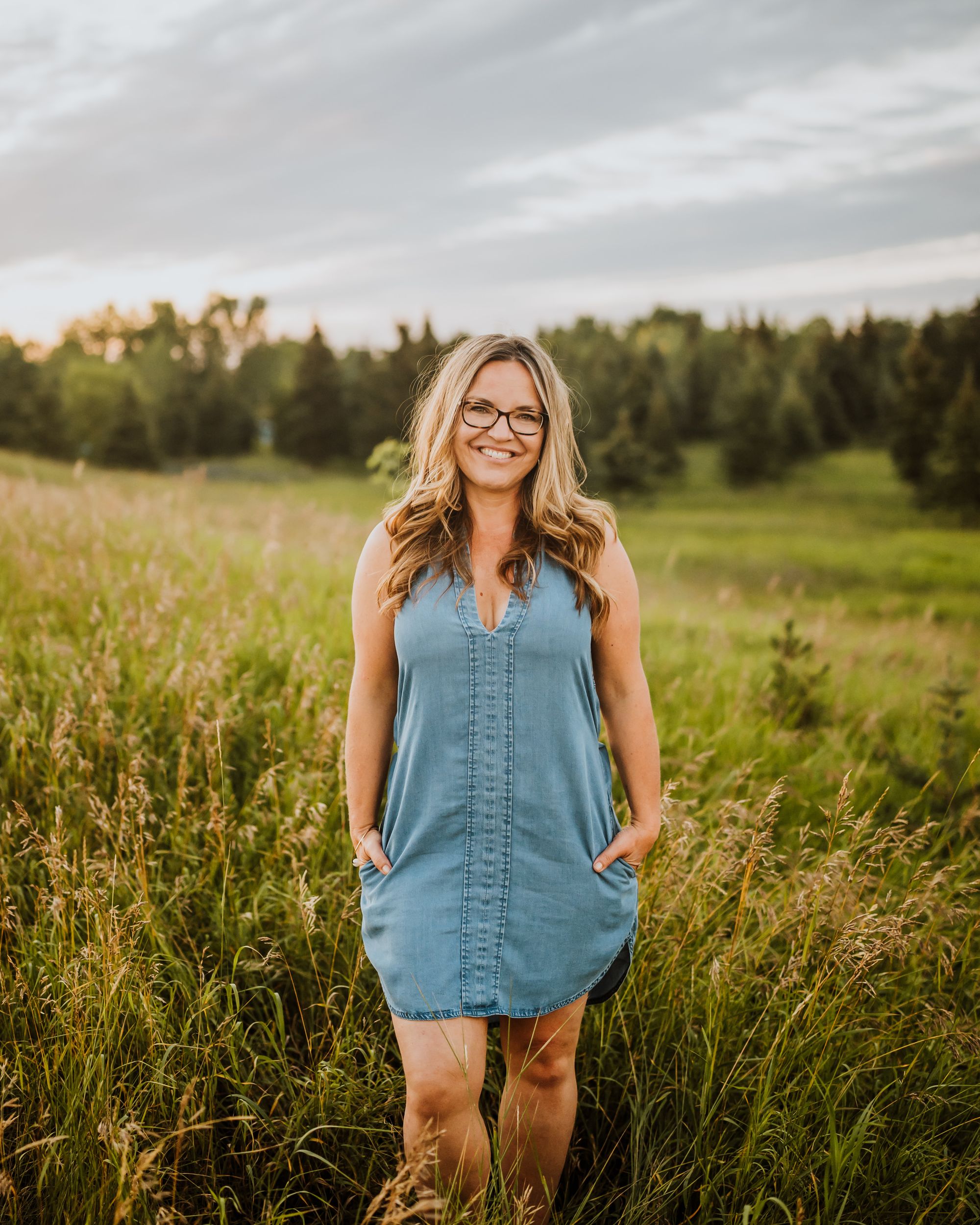 Tina Ross standing in a field of tall grass in Central Alberta