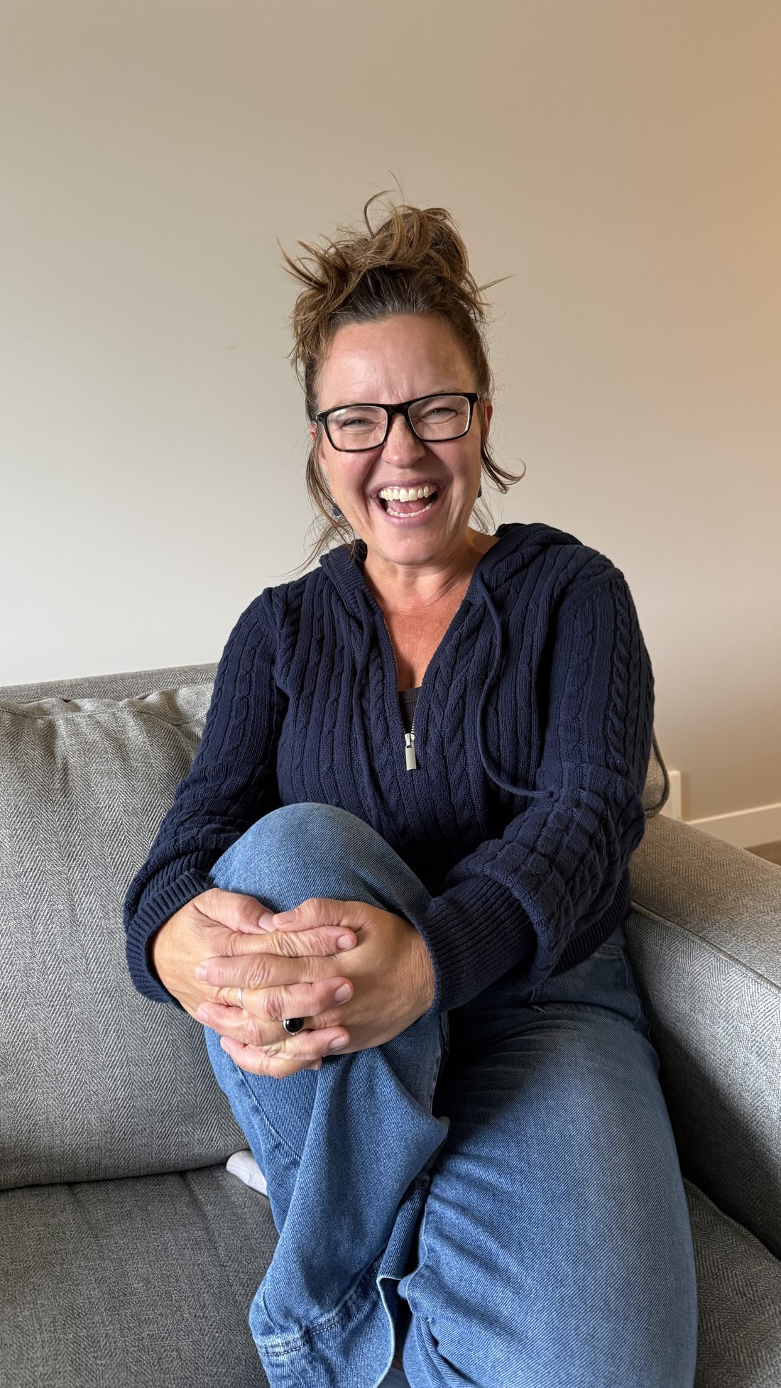 Tina Ross on a couch, smiling